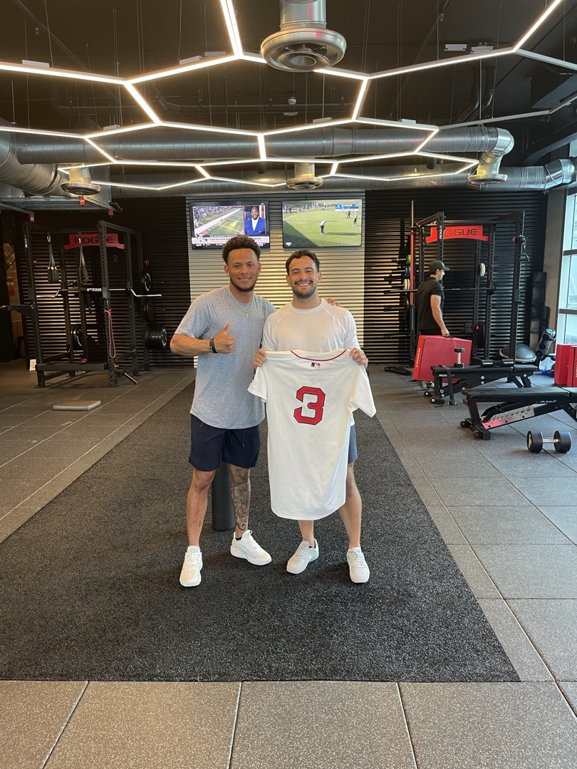 MLB athlete presenting Red Sox jersey at Crown facility