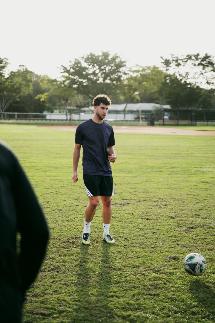 Footballer training on grass pitch